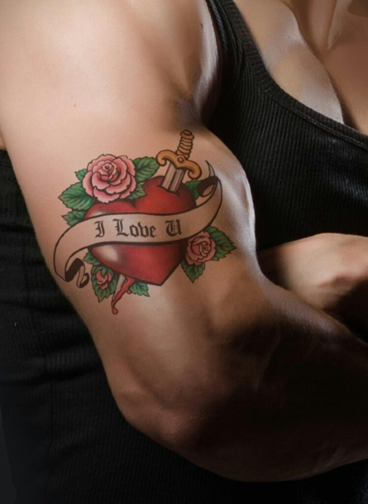 Close-up of a muscular arm with a heart and rose tattoo symbolizing love and strength.