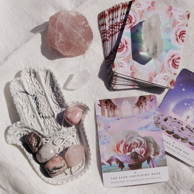 Flat lay of tarot deck, healing crystals, and oracle cards on fabric background.