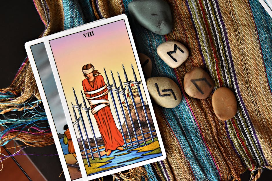 Tarot card with runes on fabric, symbolizing mystical and spiritual themes.